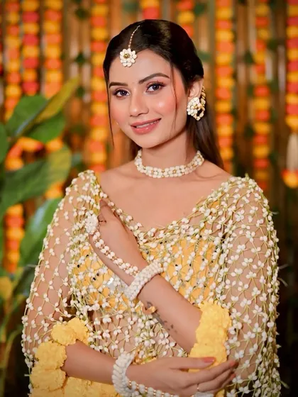 A beautiful shot capturing the intricate details of the floral jewellery and the fresh, dewy makeup.