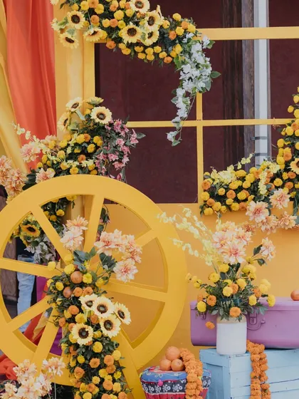 A decorative cart adorned with yellow flowers and oranges. This charming detail added a rustic and colorful touch to the overall Haldi decor.