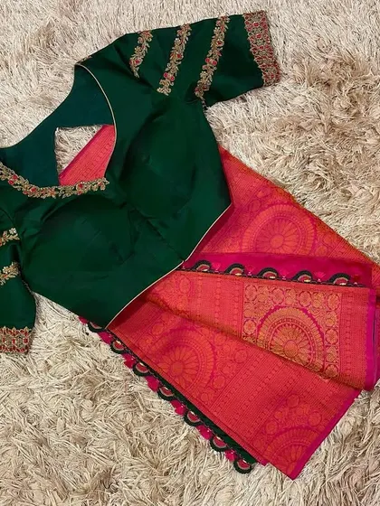 A bottle green blouse with striped embroidery on the sleeves, paired with a classic pink silk saree.
