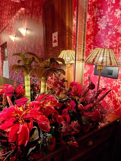 A stunning floral display in shades of red set against a red patterned wall, creating a bold, monochromatic look for the restaurant launch.