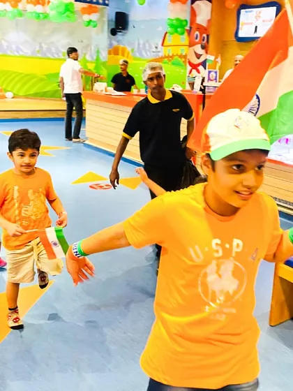 A boy leads a small parade with an Indian flag during our patriotic celebrations.