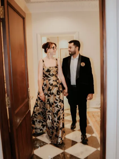 A candid shot of the couple walking down the palace corridor, hand in hand. This image captures a quiet, shared moment of happiness after the ceremony.