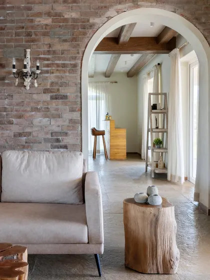 Another perspective of the living room, showing how the archway frames the view into the adjacent bar area, creating depth and visual interest.