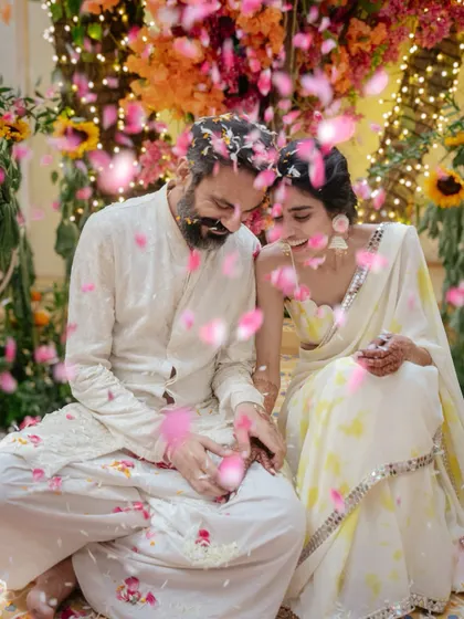 Nikki and Vishal are showered with pink and yellow petals during their haldi. This beautiful, colorful moment captures the love and joy surrounding them as they celebrate with their closest family.