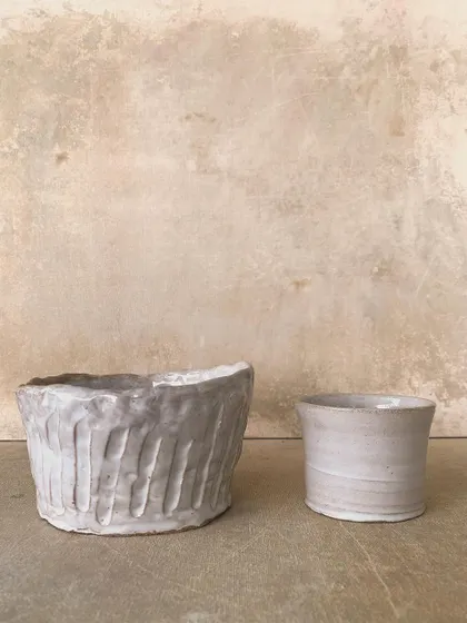 Two small, hand-built pots, one with a textured surface and the other with a smooth finish. They show the different possibilities of working with clay.