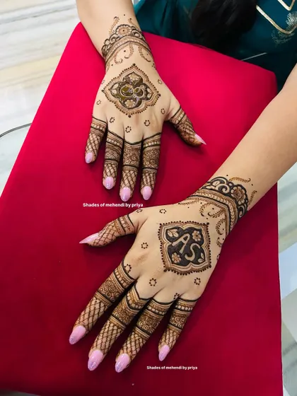 A closer look at the hand designs for the engagement, showing the personalized initials. This is a popular way to customize bridal mehendi.