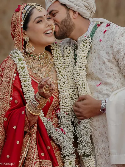 A candid moment of affection between Jigar and Amruta. The groom's playful kiss and the bride's joyful laugh perfectly capture the fun and love that defined their wedding day.