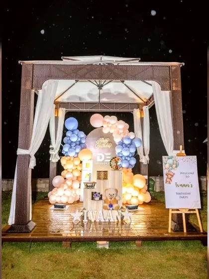 An elegant outdoor teddy bear-themed birthday party set up inside a gazebo, creating a cozy and charming atmosphere with soft colors and cute props.
