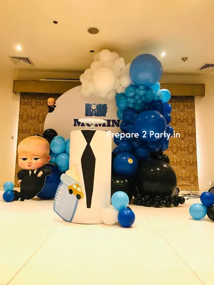 A full view of the "Boss Baby" first birthday setup, including the custom pedestal designed to look like a suit and tie, perfectly matching the theme.