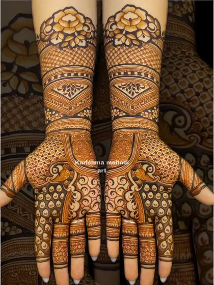This design showcases peacocks on the palms with their feathers creating a swirling, intricate pattern. The arms feature geometric bands and a bold floral cuff for a modern yet traditional feel.