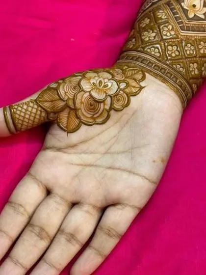 A beautiful close-up of a single shaded rose design on the thumb, part of a larger piece, showcasing our skill in creating realistic floral elements.