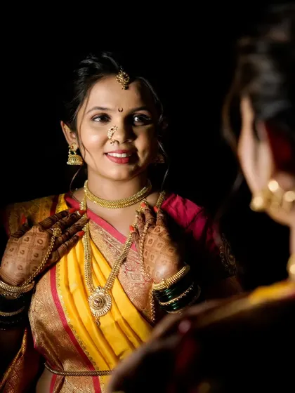 A full reflection of the bride in her stunning yellow nauwari, a perfect shot to capture the complete traditional look.
