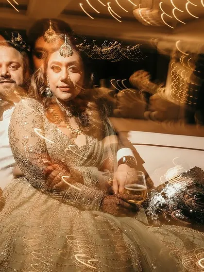A creative double-exposure style shot of the couple, blending their portraits with the ambient light trails of the party. An artistic and unique memory.