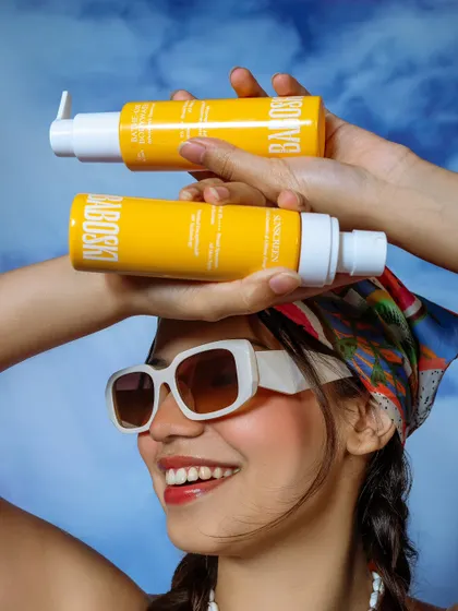 A creative product shot for a skincare brand, using the model to playfully showcase the products.