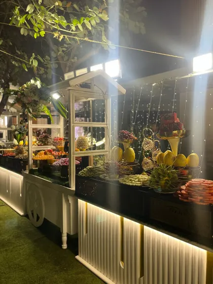 A fruit station with a white cart and elegant lighting.