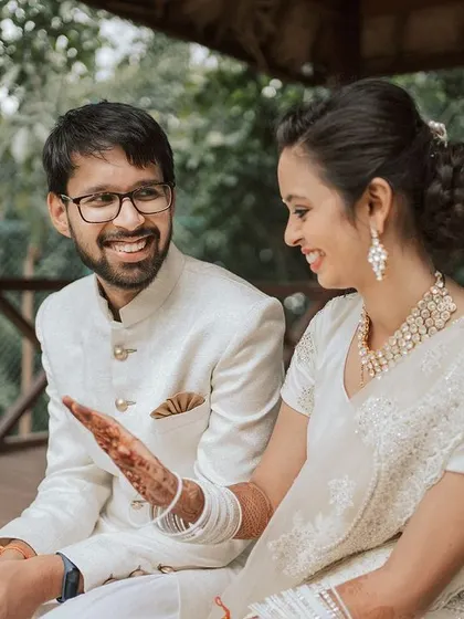 The bride shows her intricate henna design to the groom, a sweet and personal moment from their celebration.