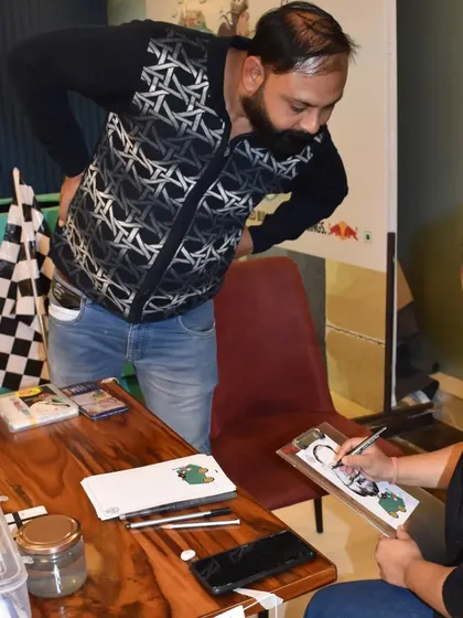 A candid moment of a guest watching me draw his caricature, a fun part of the interactive experience.