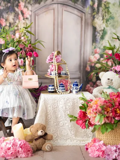 A little fashionista with her pink purse at a floral tea party. My studio is filled with props to spark imagination and create playful portraits.