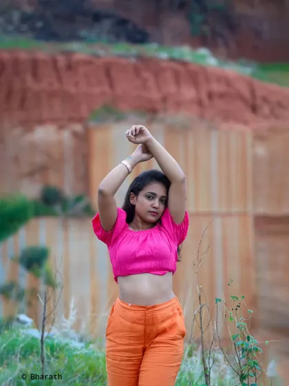 This powerful pose with arms raised creates a strong silhouette against the textured background of the quarry.