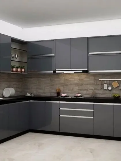 This is a classic L-shaped modular kitchen with glossy grey handleless cabinets. The design maximizes storage and provides a clean, modern aesthetic, complemented by a brick-patterned backsplash.