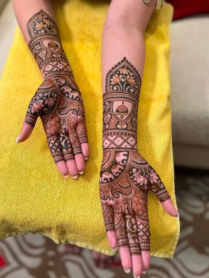 A beautiful design for a family member or guest, featuring elephant motifs and architectural details. It's intricate but not as dense as a full bridal design.
