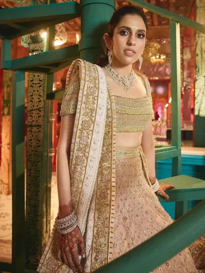 Another angle of the peach lehenga, showing the beautiful silhouette against the spiral staircase.