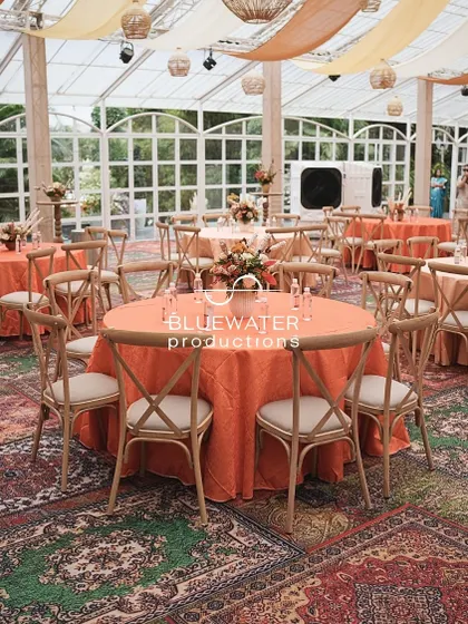 Guest dining tables are set on a floor of layered Persian-style carpets.