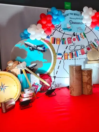 A close-up of the props, including a large compass, vintage suitcases, and airplane models.