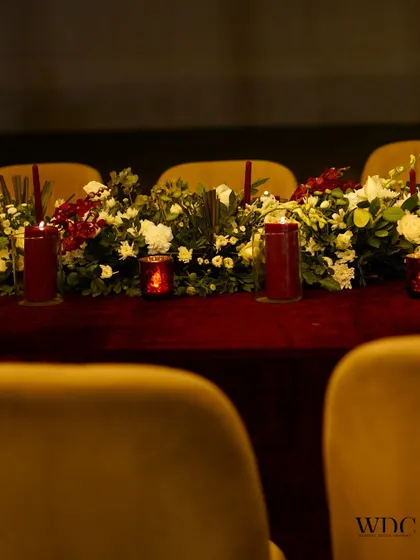 A royal tabletop setting with a rich red velvet cloth and a runner of white and red flowers. This setup is a must for a special day that calls for regal aesthetics.