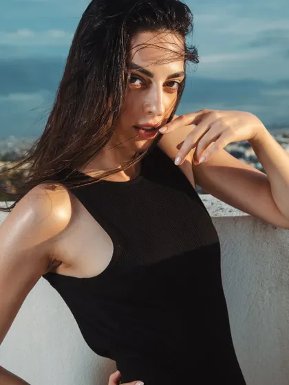 Another shot from the rooftop series, capturing the windswept hair and glowing skin in the natural light.
