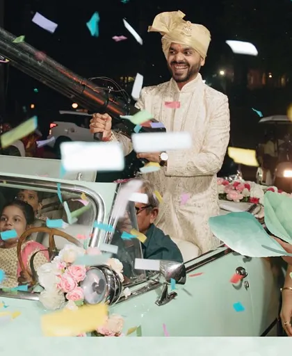 We believe the groom's entry should be just as dramatic as the bride's. Here, the groom makes his grand entrance in a vintage car, firing a confetti gun to kick off the baraat with incredible energy and style.