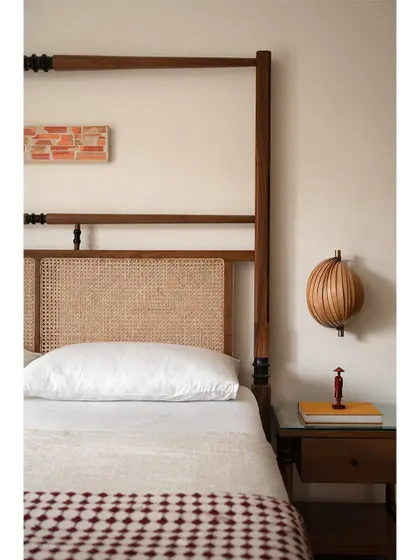The classic combination of rattan and wood is always a winner. This close-up of the bed in 'Kayu' highlights the beautiful texture of the cane headboard and the warmth of the wood, creating a timeless and inviting look.