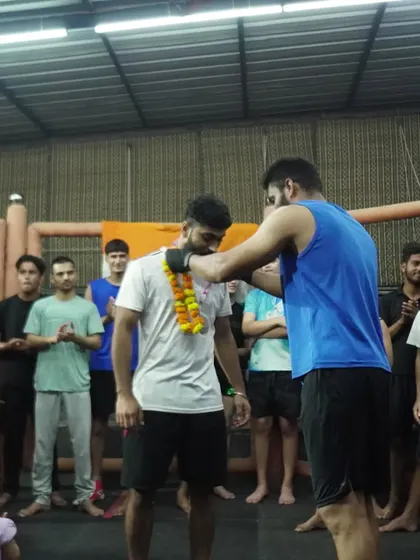 A teammate garlands a returning champion, a sign of respect and shared success within our gym.