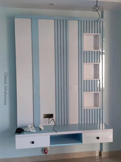 Another TV unit design from the same project, this one uses vertical louvers and stripes in a calming blue and white palette. The floating design includes display niches and a console.