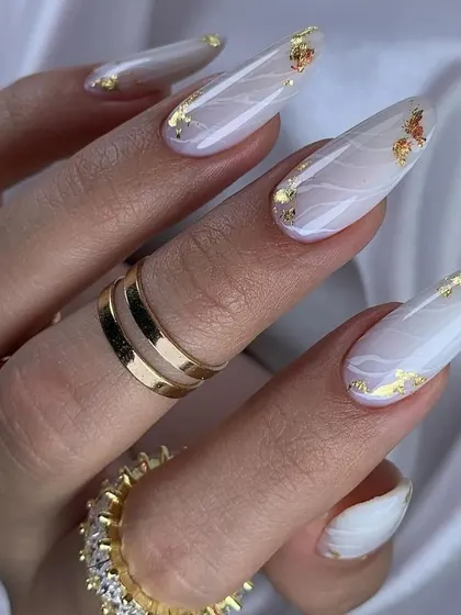 Experience elegance with our marble nail art. This design features long, almond-shaped nails with a soft white marble effect, beautifully accented with delicate flecks of gold foil for a touch of luxury.