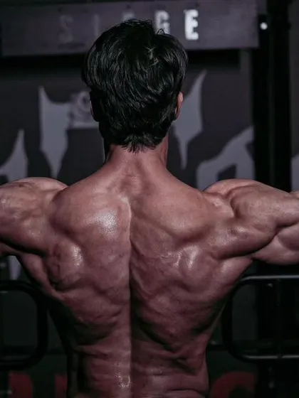 Pressure is a privilege. A powerful back pose that turns the stress of training into a symbol of honor and strength.