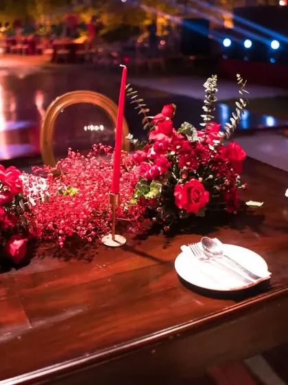 A bold and passionate dining statement. This reception table is styled with rich red florals, matching candles, and elegant tableware, creating a dramatic and romantic atmosphere for the wedding feast.