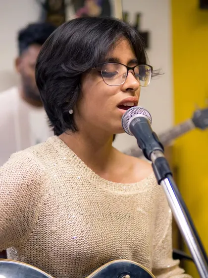 A close-up of a vocalist, mid-song, during an artist showcase. The passion and talent of the artists we host is truly inspiring.