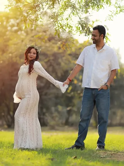 A romantic walk in the park, with the mother-to-be in a lovely white lace gown. The golden hour lighting creates a soft and dreamy feel.