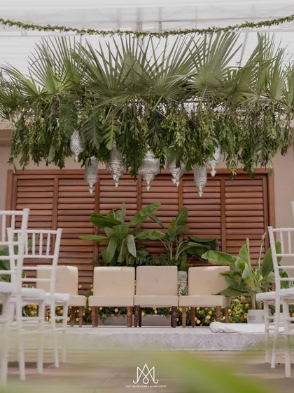 A clean and minimalist mandap setup, using natural elements like palm fronds and banana plants against a wooden backdrop, perfect for an understated, elegant ceremony.