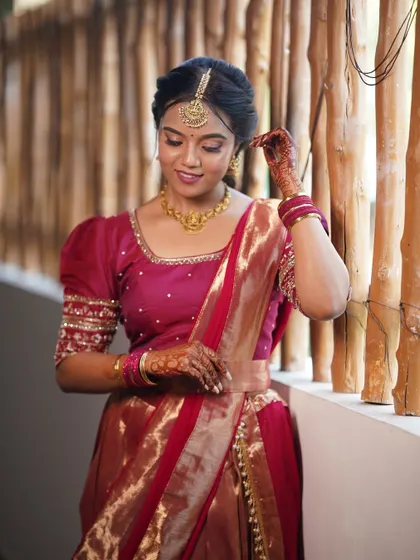 A beautiful shot of this bride in her traditional half saree. The makeup is soft and natural, with a focus on a flawless complexion that looks incredible in professional photos.