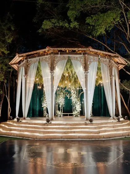 A full view of the elegant green and white Sangeet stage, with a custom dance floor ready for a night of celebration.