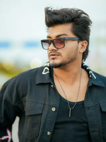 A close-up portrait of a male model with a blurred, bokeh background, creating a professional and polished look.