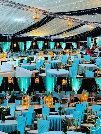 The interior of a large tent decorated for a reception in a striking turquoise and black theme.