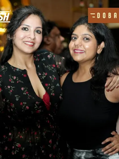 Two friends enjoying the music and each other's company at the Independence Day bash.