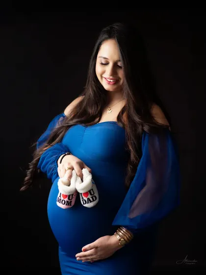 A close-up shot focusing on the baby bump and the adorable "I love Mom" and "I love Dad" shoes. It's a perfect detail shot for your gallery.