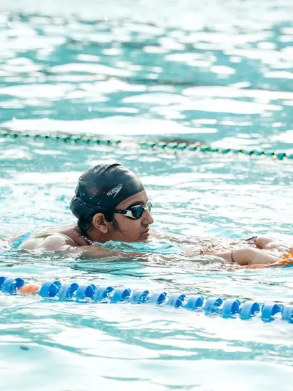 This young swimmer is building confidence and technique using a kickboard, a fundamental tool in our learn-to-swim program.