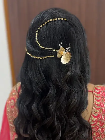 A simple open hairstyle with soft waves, elevated by a unique gold chain and butterfly accessory. This is a modern and stylish way to adorn open hair.