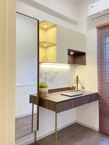 The study area in the kid's room is separated by a sleek fluted glass partition. The space is functional and stylish, with a modern desk and overhead storage.