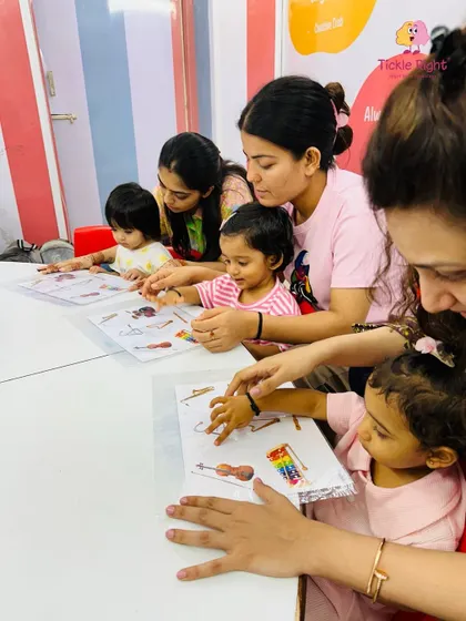 A mother and child work together on a worksheet, showcasing the hands-on, parent-involved nature of our classes. We believe in learning as a partnership between trainer, parent, and child.